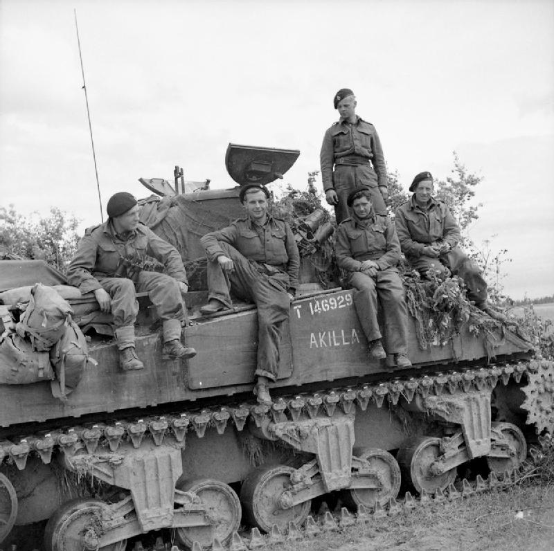 The crew of a Sherman tank named ‘Akilla’ of 1st Nottinghamshire Yeomanry, 8th Armoured Brigade, after having destroyed five German tanks in a day, Rauray, Normandy, 30 June 1944.